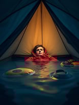 A Man Inside of a Flooded Tent