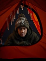 A Man Wearing a Knit Cap Inside a Tent in Cold Weather